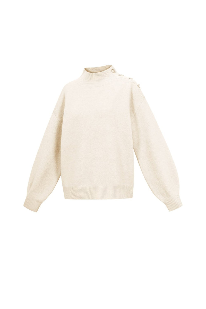 Strickpullover mit goldenen Knöpfen in weiß