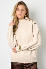 Strickpullover mit goldenen Knöpfen in weiß